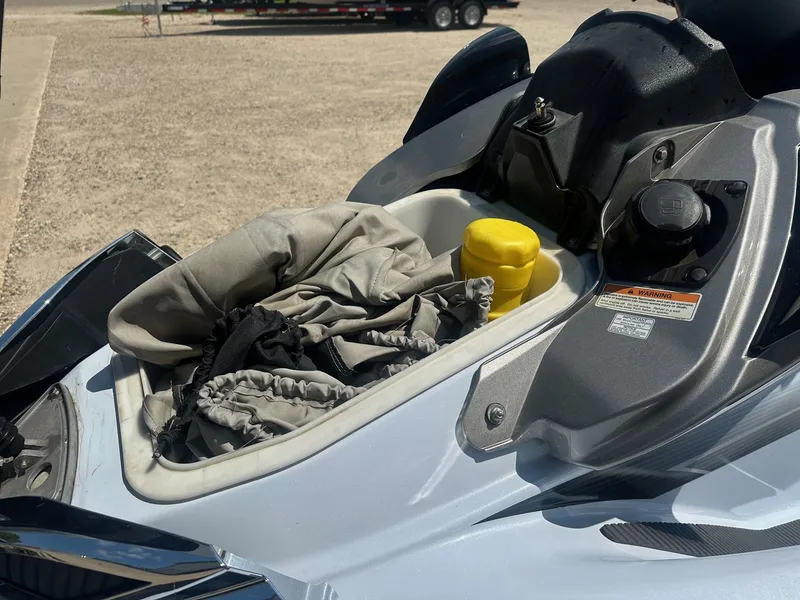 Slide: The Image of 2012 Kawasaki 300 LX Ultra storage compartment with cover and yellow container. - 7