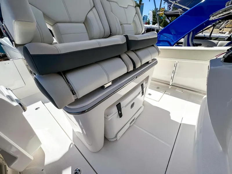 Slide: The Image of 2025 Edgewater 262CC boat interior with cushioned seating and storage compartment. - 10