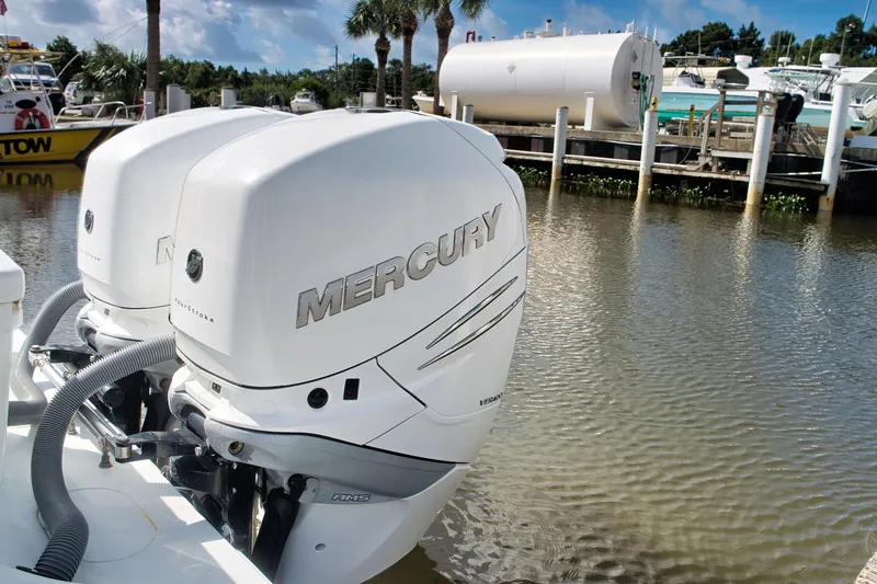 Slide: The Image of Twin Mercury outboard engines on a 2017 Yellowfin 32 Offshore boat docked by the water. - 10
