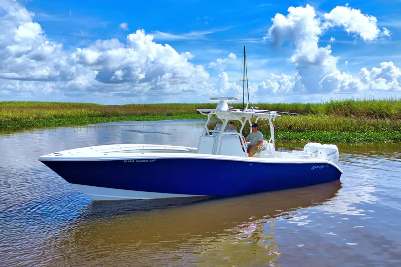 Slide: The Image of 2017 Yellowfin 32 Offshore boat cruising on a calm river under a blue sky. - 4