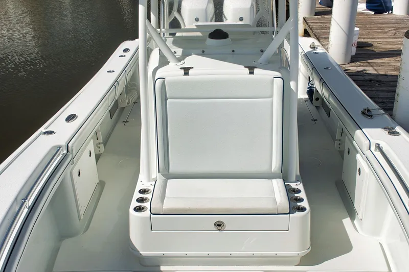 Slide: The Image of 2017 Yellowfin 32 Offshore boat interior with seating and cup holders, docked by the water. - 6