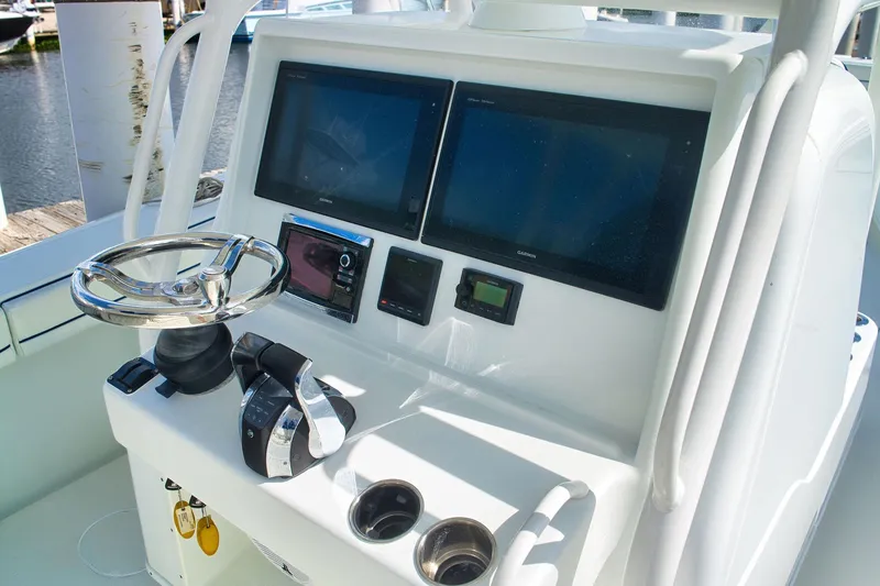 Slide: The Image of 2017 Yellowfin 32 Offshore boat dashboard with steering wheel and navigation screens. - 9