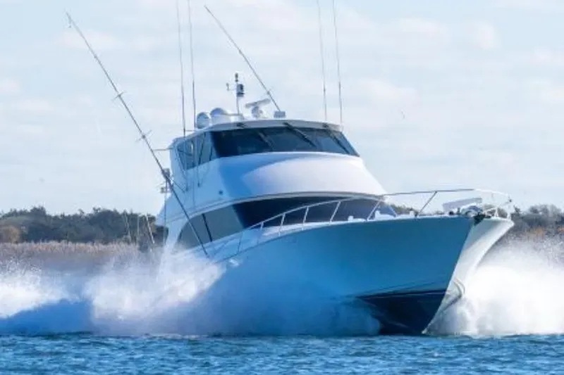 The Image of 2002 Viking 61 Enclosed Bridge yacht cruising on open water, creating a dynamic splash. - 0