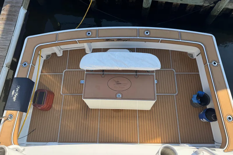 Slide: The Image of 2002 Viking 61 Enclosed Bridge boat deck with teak flooring and fishing equipment. - 11