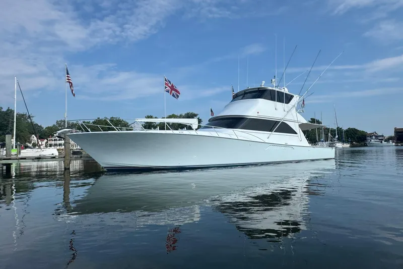 Slide: The Image of 2002 Viking 61 Enclosed Bridge yacht docked on calm water under blue sky. - 2