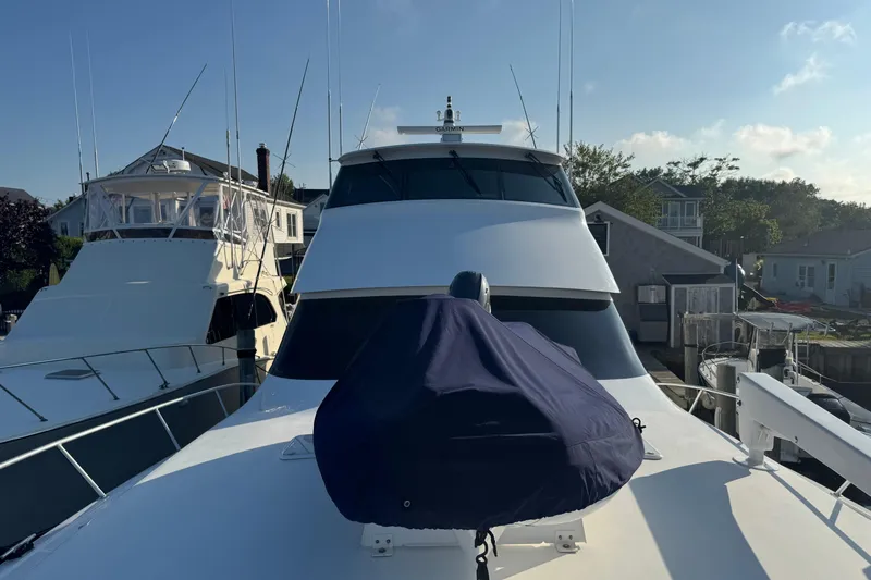 Slide: The Image of 2002 Viking 61 Enclosed Bridge yacht docked, featuring sleek design and covered equipment. - 28