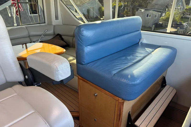 Slide: The Image of Interior of 2002 Viking 61 Enclosed Bridge with blue seating and wooden accents. - 49