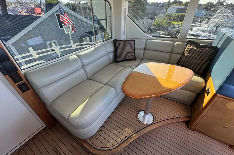 Slide: The Image of Luxurious interior of 2002 Viking 61 Enclosed Bridge yacht with leather seating and wooden table. - 52