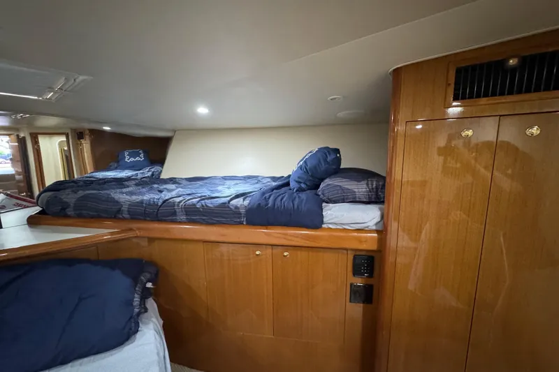 Slide: The Image of Interior cabin of 2002 Viking 61 Enclosed Bridge yacht with cozy bedding and wooden cabinetry. - 71