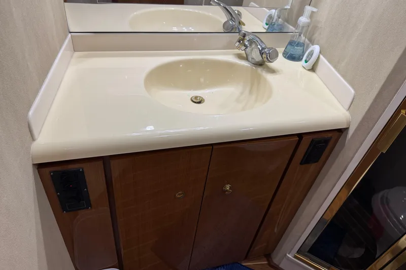 Slide: The Image of Bathroom sink and cabinet on a 2002 Viking 61 Enclosed Bridge yacht. - 74