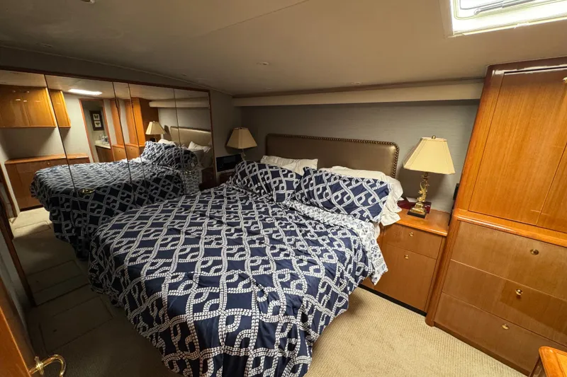 Slide: The Image of Luxurious bedroom in 2002 Viking 61 Enclosed Bridge yacht with nautical-themed bedding. - 75