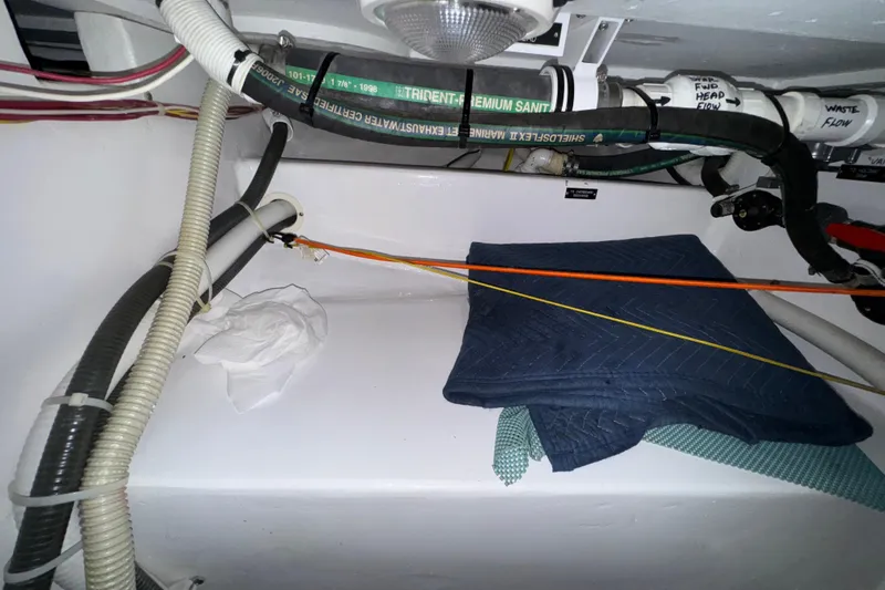 Slide: The Image of Engine room of 2002 Viking 61 Enclosed Bridge with hoses and cables visible. - 82