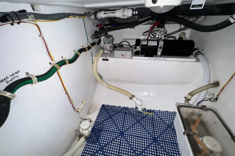 Slide: The Image of Engine room of 2002 Viking 61 Enclosed Bridge yacht, showcasing hydraulic systems and piping. - 83