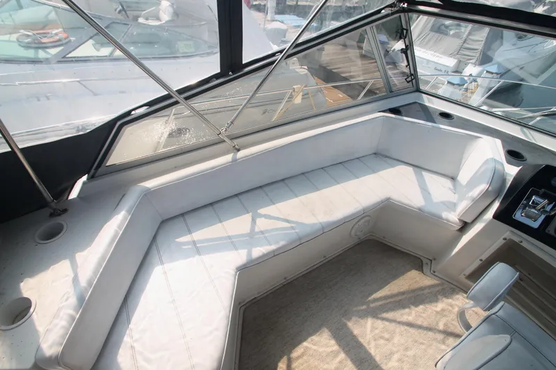 Slide: The Image of 1995 Carver 330 Mariner interior with white seating and helm, showcasing spacious design. - 13