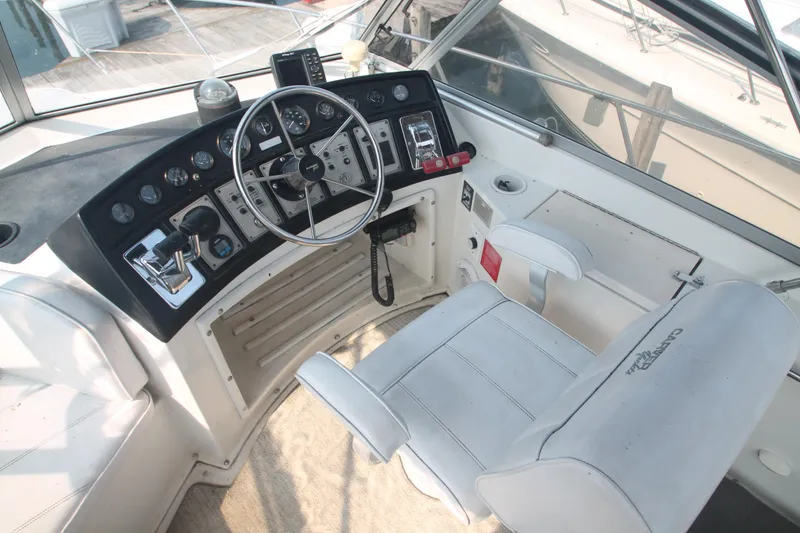 Slide: The Image of 1995 Carver 330 Mariner helm with steering wheel, controls, and captain's chair. - 15