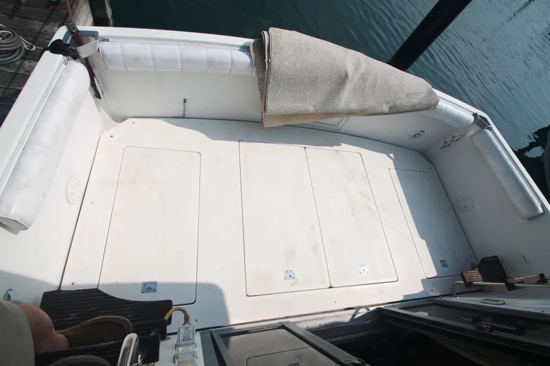 Slide: The Image of 1995 Carver 330 Mariner boat deck with white seating and storage compartments. - 46
