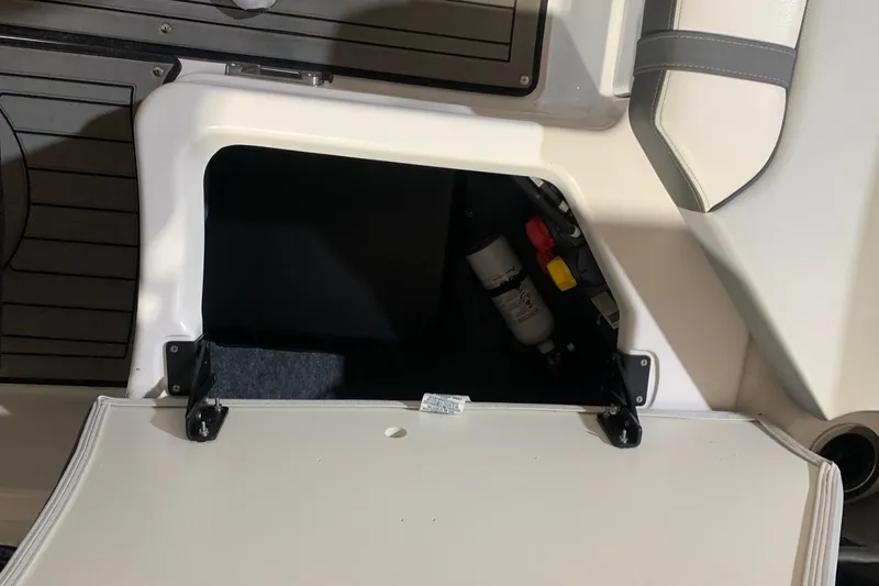 Slide: The Image of 2017 Yamaha Boats 212 Limited storage compartment with open hatch, revealing interior components. - 21
