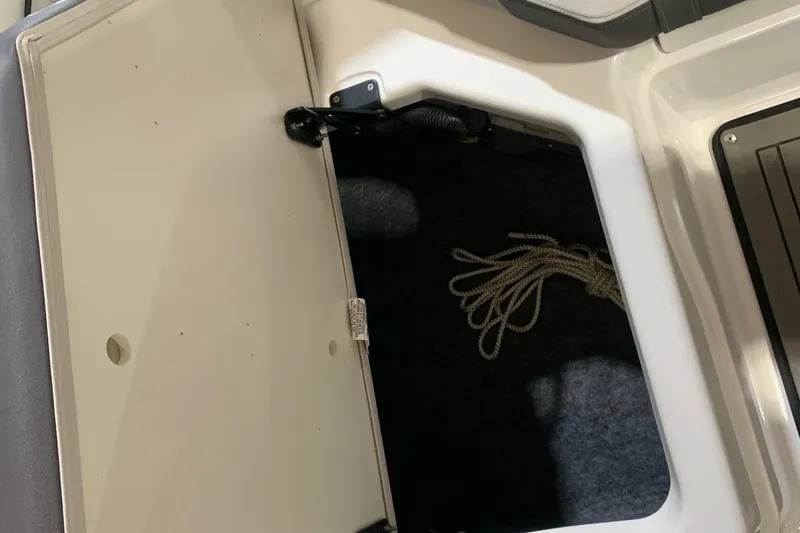 Slide: The Image of Open storage compartment in 2017 Yamaha Boats 212 Limited, featuring a coiled rope inside. - 23