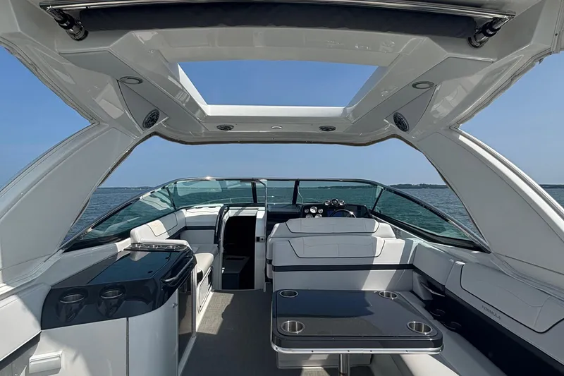 Slide: The Image of 2021 Formula 350ss luxury boat interior with open roof and seating, on a calm sea. - 15