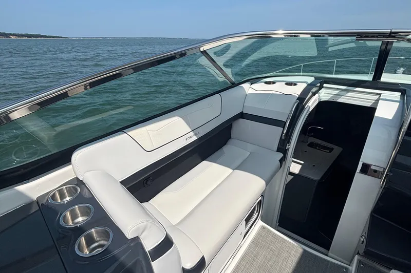 Slide: The Image of 2021 Formula 350ss boat interior with white seating and cup holders, overlooking the ocean. - 18