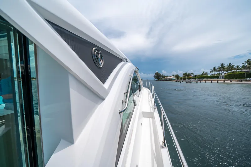 Slide: The Image of 2019 Cruisers Yachts Cantius sailing on a scenic waterway under a clear sky. - 18