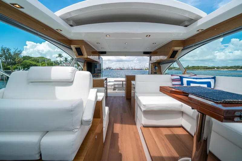 Slide: The Image of Luxurious 2019 Cruisers Yachts Cantius interior with white seating and wooden accents, overlooking the water. - 2
