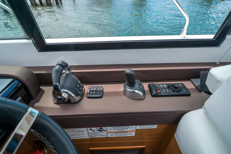 Slide: The Image of 2019 Cruisers Yachts Cantius helm controls with joystick and throttle, overlooking water. - 28