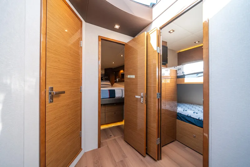 Slide: The Image of Luxurious 2019 Cruisers Yachts Cantius interior with wooden doors and cozy cabin beds. - 31