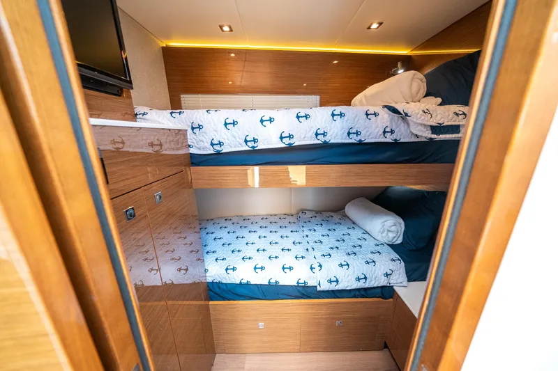 Slide: The Image of 2019 Cruisers Yachts Cantius cabin with bunk beds and nautical-themed bedding. - 35