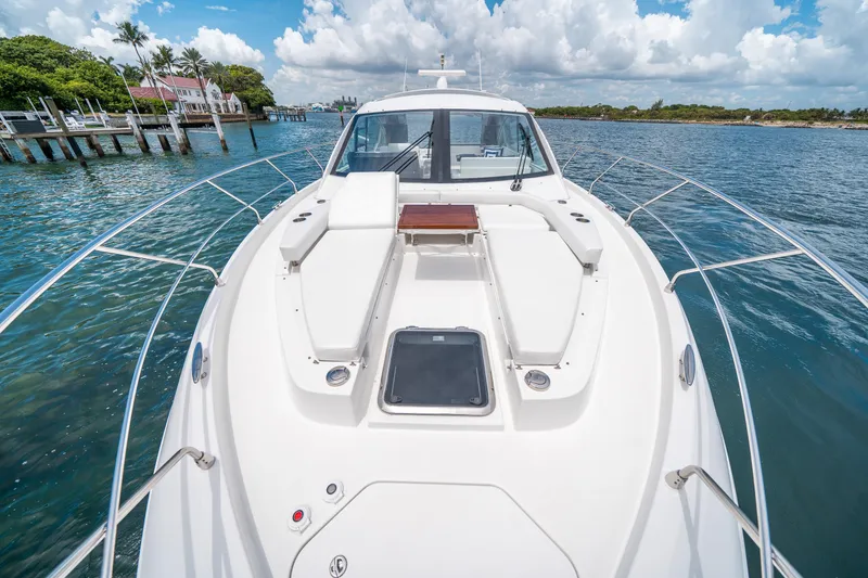 Slide: The Image of 2019 Cruisers Yachts Cantius on serene water, showcasing sleek deck design and luxurious seating. - 5