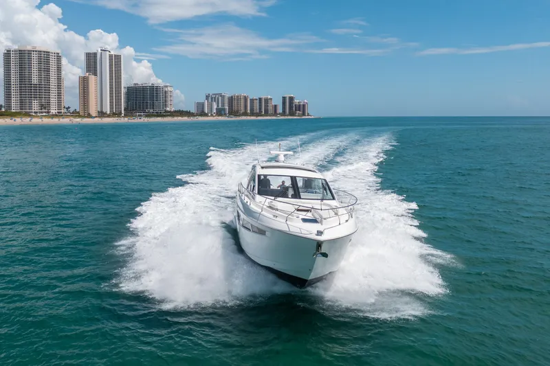 Slide: The Image of 2019 Cruisers Yachts Cantius speeding on ocean near city skyline. - 59