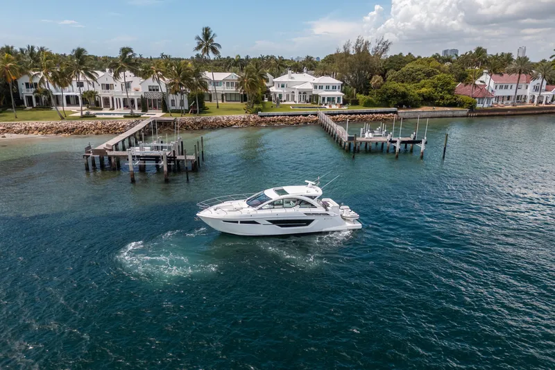 Slide: The Image of 2019 Cruisers Yachts Cantius sailing near luxury waterfront homes and docks. - 61