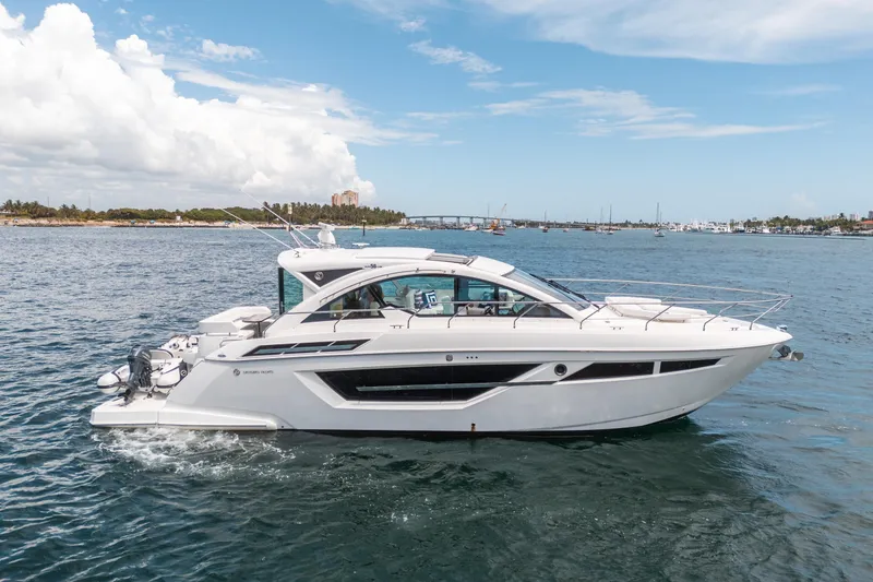 Slide: The Image of 2019 Cruisers Yachts Cantius on open water, sleek design, clear sky background. - 63