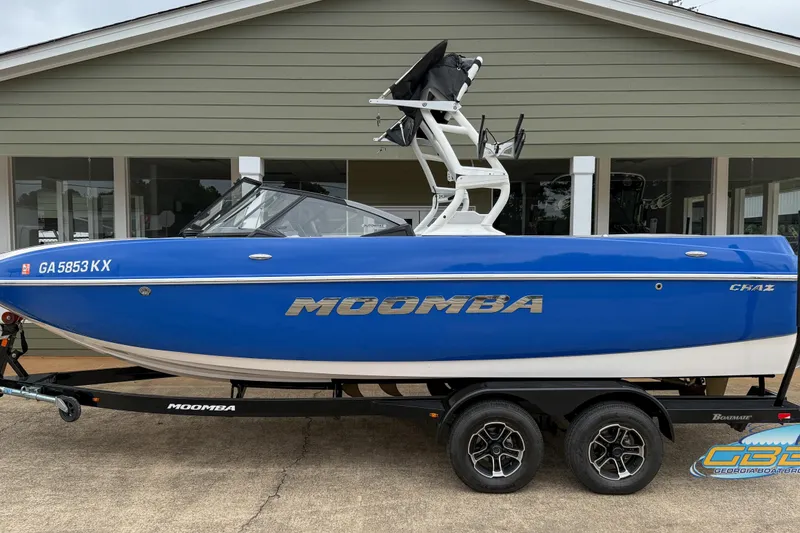 Slide: The Image of 2021 Moomba Craz boat in blue on trailer, parked outside a building. - 15