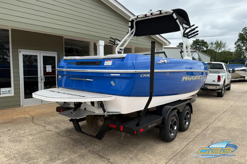 Slide: The Image of 2021 Moomba Craz boat in blue, parked on a trailer outside a building. - 19