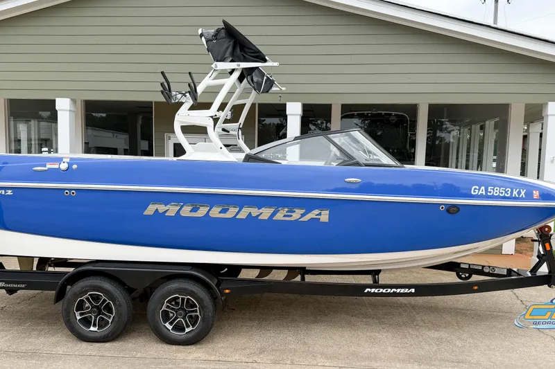Slide: The Image of 2021 Moomba Craz boat in blue on trailer, parked outside a building. - 20