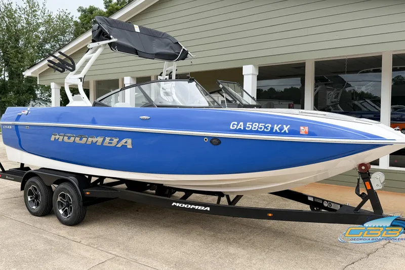 Slide: The Image of 2021 Moomba Craz boat in blue, parked on a trailer outside a building. - 21