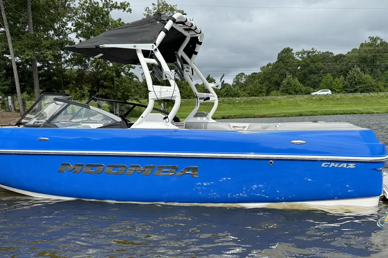 Slide: The Image of 2021 Moomba Craz boat in vibrant blue on a calm lake. - 8
