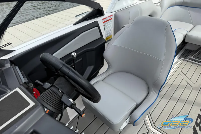 Slide: The Image of 2021 Moomba Craz boat interior with steering wheel and seating, dockside view. - 9