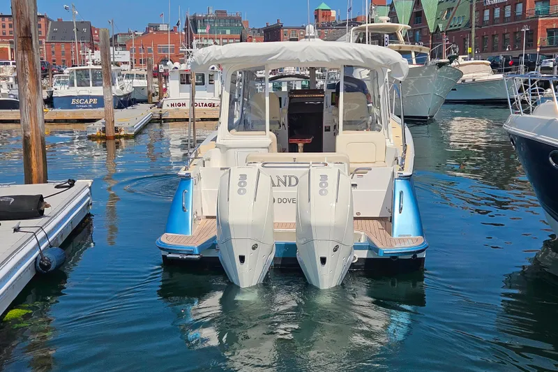 Slide: The Image of 2023 MJM 35 boat docked in a marina with twin outboard engines. - 10