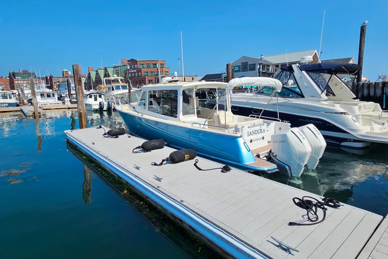 Slide: The Image of 2023 MJM 35 boat docked in a marina, surrounded by other vessels. - 11