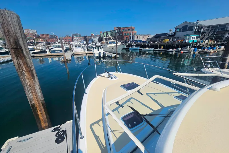 Slide: The Image of 2023 MJM 35 boat docked in a bustling marina with clear blue skies. - 16