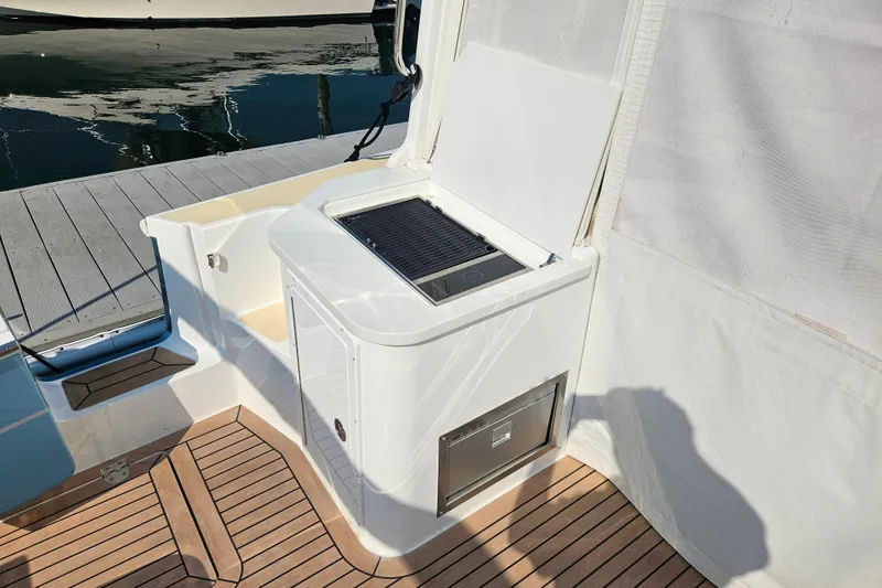 Slide: The Image of 2023 MJM 35 yacht deck with built-in grill and storage, docked by the water. - 40