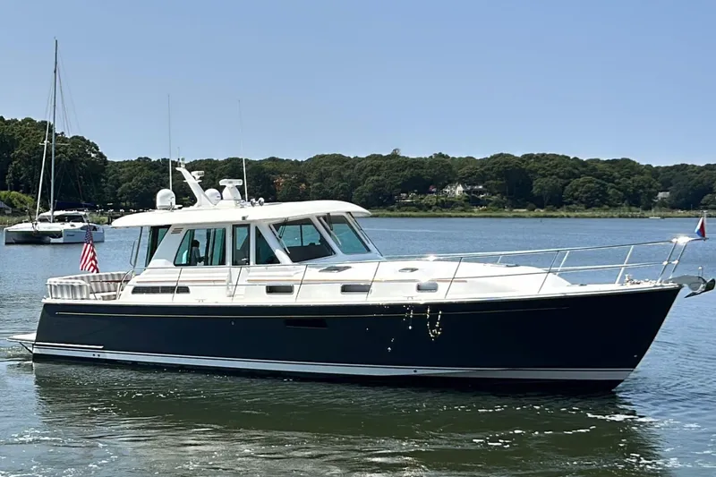 The Image of 2022 Sabre 48 Salon Express yacht on serene water with scenic background. - 0