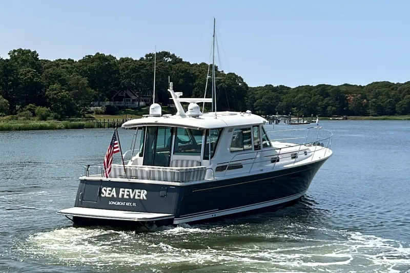 Slide: The Image of 2022 Sabre 48 Salon Express yacht cruising on a scenic river. - 3