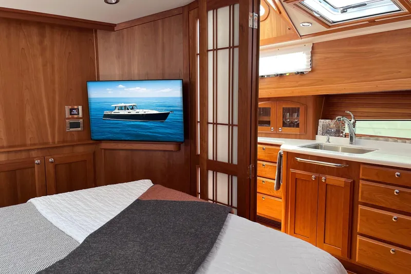 Slide: The Image of 2022 Sabre 48 Salon Express yacht with American flag, striped seating, and wooden table. - 43