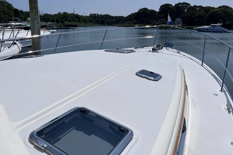 Slide: The Image of 2022 Sabre 48 Salon Express yacht on calm water under a clear blue sky. - 46