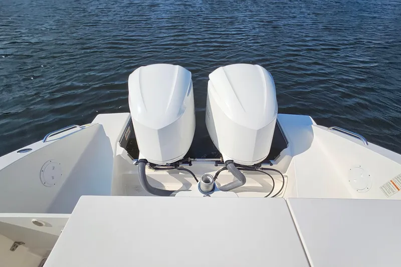 Slide: The Image of 2018 Pursuit DC 295 Dual Console boat with twin outboard engines on water. - 14