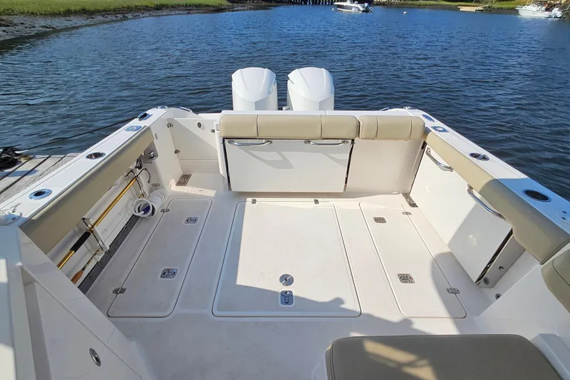 Slide: The Image of 2018 Pursuit DC 295 Dual Console boat interior with spacious deck and seating. - 15