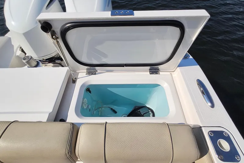 Slide: The Image of 2018 Pursuit DC 295 Dual Console boat with open storage compartment. - 17